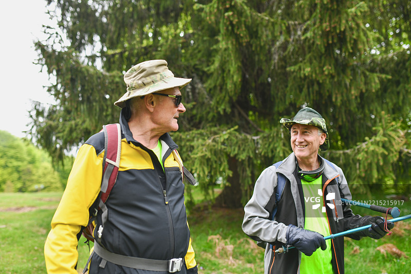 男性朋友们享受周末的山间徒步旅行，携带登山装备图片素材
