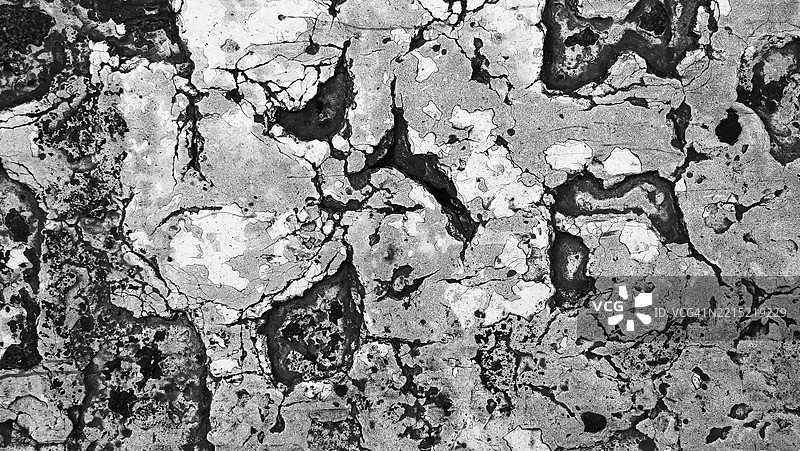 墙面上风化和开裂的白色与灰色油漆层。粗糙的纹理。阳光。黑白色调。西班牙塞维利亚。全画幅16x9。图片素材