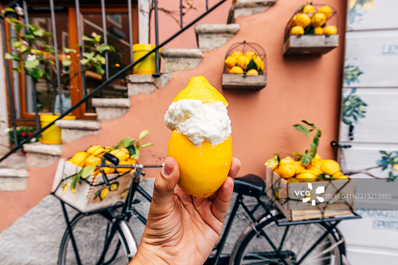 手持新鲜柠檬盛装的柠檬冰淇淋，个人视角，意大利加尔达湖的利莫内苏尔加尔达图片素材