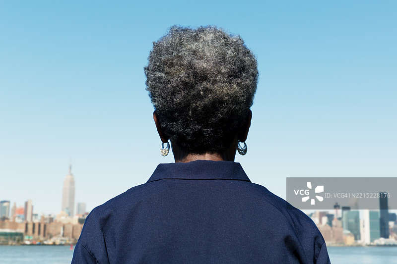 女人背对着曼哈顿天际线，纽约图片素材