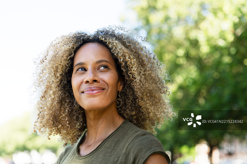 快乐的女人在阳光明媚的日子里仰望天空图片素材