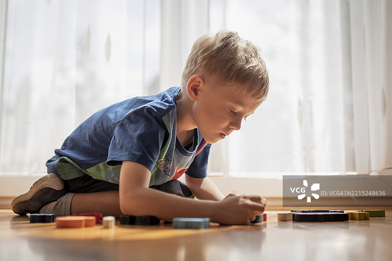 5-6岁的小男孩在玩积木拼图图片素材