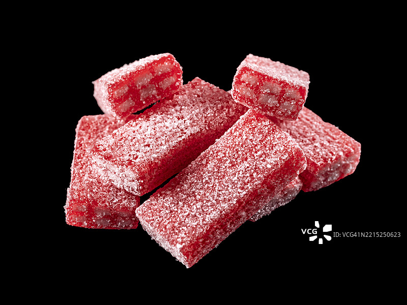 黑色背景上有很多柔软的草莓味甘草糖。图片素材