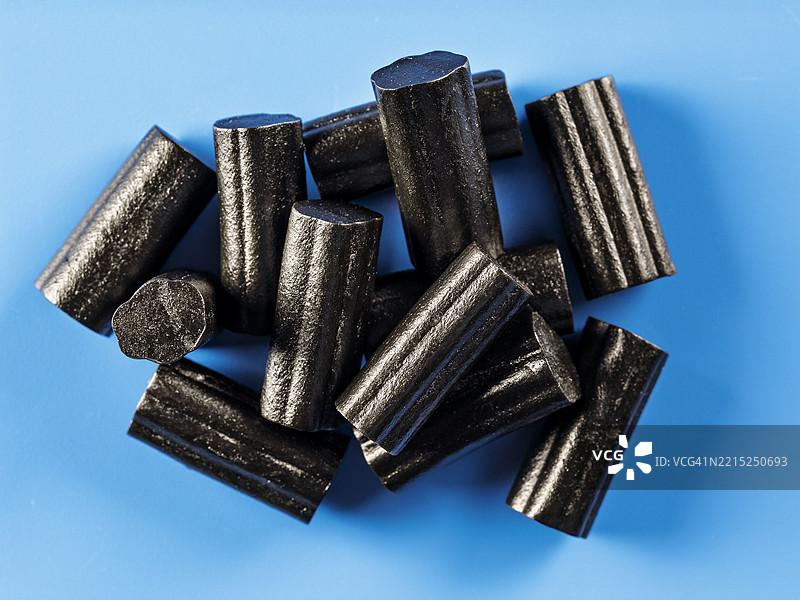 蓝色背景上的软甘草糖果。图片素材