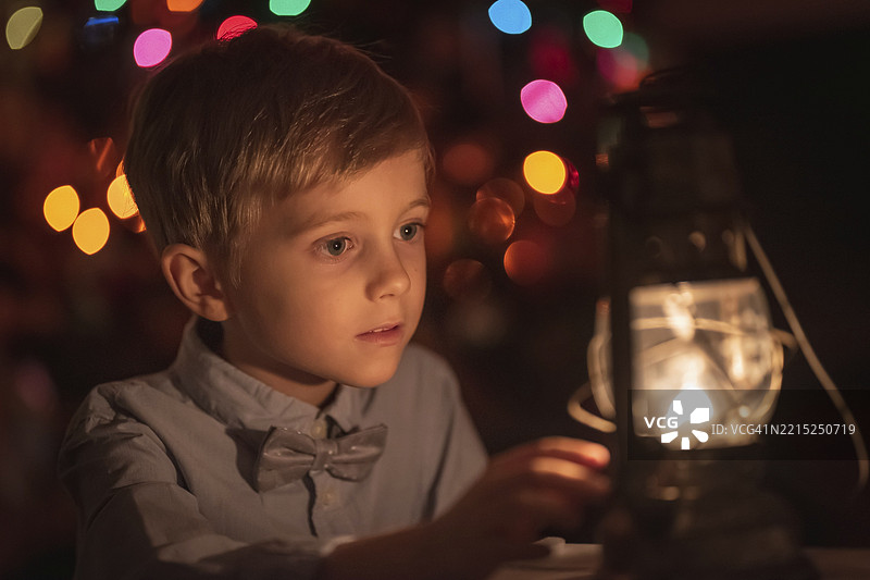 6岁小孩的肖像，背景有油灯和圣诞树图片素材