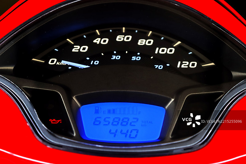 红色摩托车的照明仪表盘，显示速度表和指示里程及其他车辆信息的数字显示屏图片素材