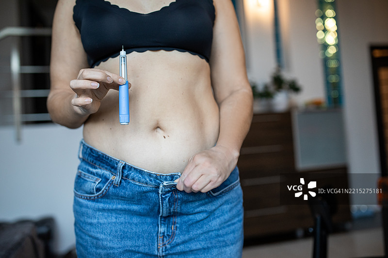现代糖尿病治疗：女性在家自我注射胰岛素 - 身体积极，包容性医疗图片素材