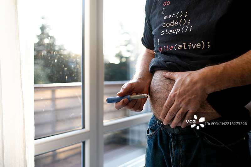 皮下注射：男子在家中自行给药 - 胰岛素，糖尿病，自我护理，医疗保健，治疗，腹部，注射笔图片素材