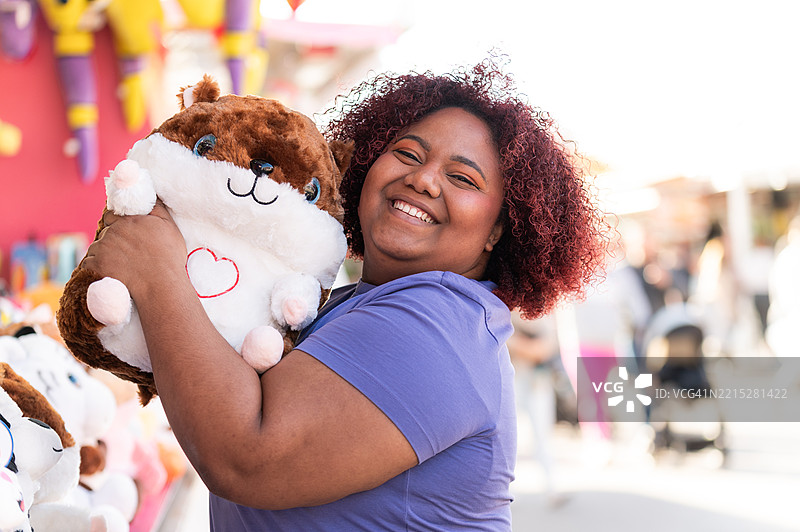 游客在游乐园里抱着毛绒玩具图片素材