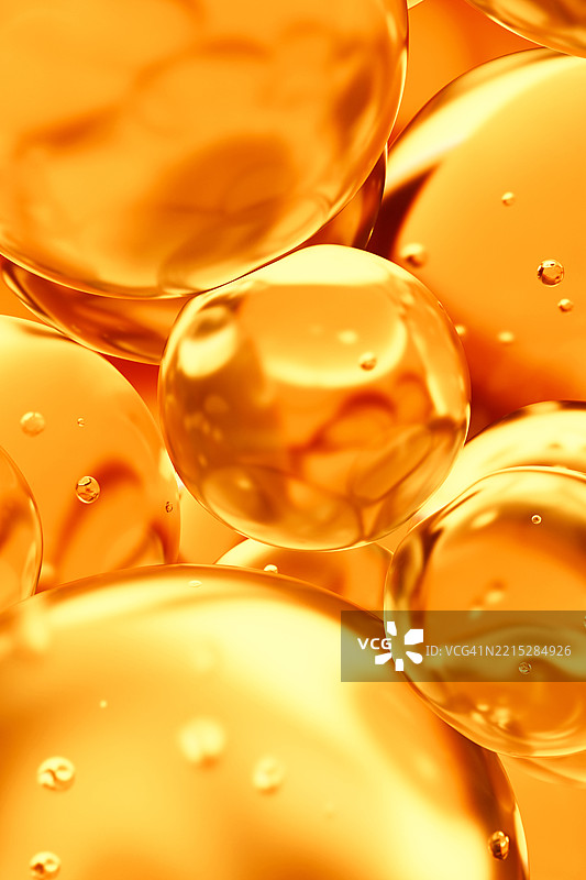 透明的黄色和橙色油滴、气泡、分子。特写。3D垂直图案。医疗保健与医学。护肤化妆品。柑橘。维生素C。图片素材