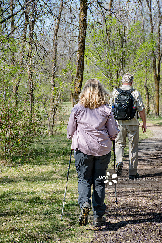 老年夫妇徒步旅行：在小径上引领方向图片素材