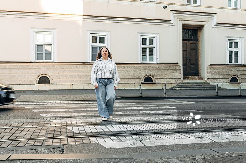女性在市中心的人行横道上过马路图片素材