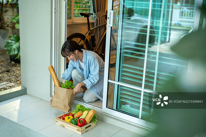 女人在后院门口整理新鲜的杂货图片素材