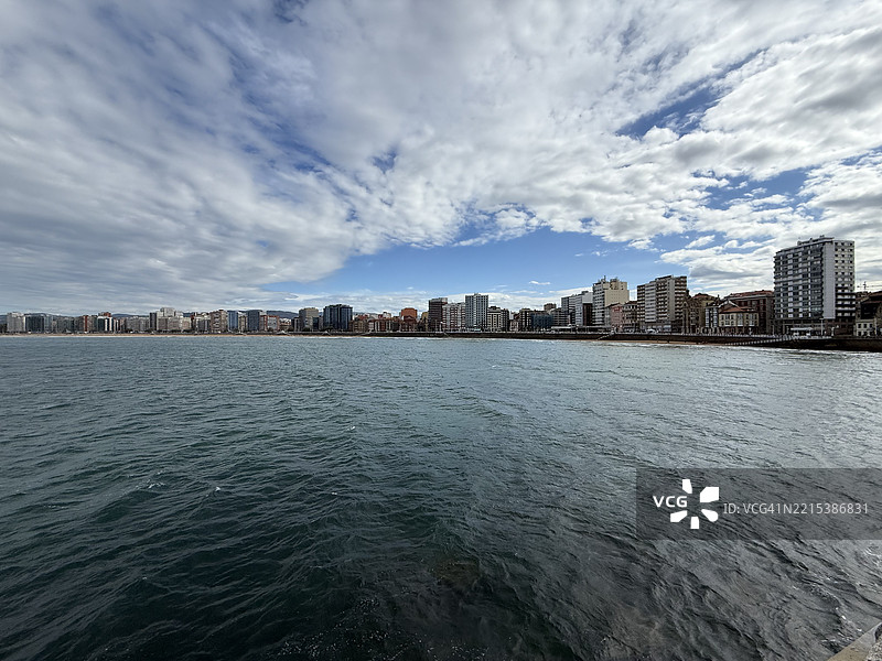 希洪市景，展现了圣洛伦佐海滩和多云天空下的坎塔布里亚海。图片素材