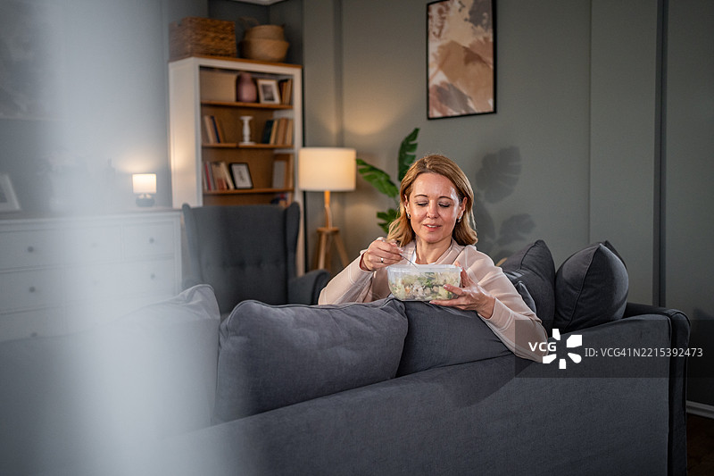 中年女性在家享用健康沙拉图片素材