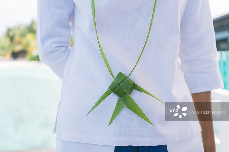 手持棕榈叶工艺品的女性图片素材