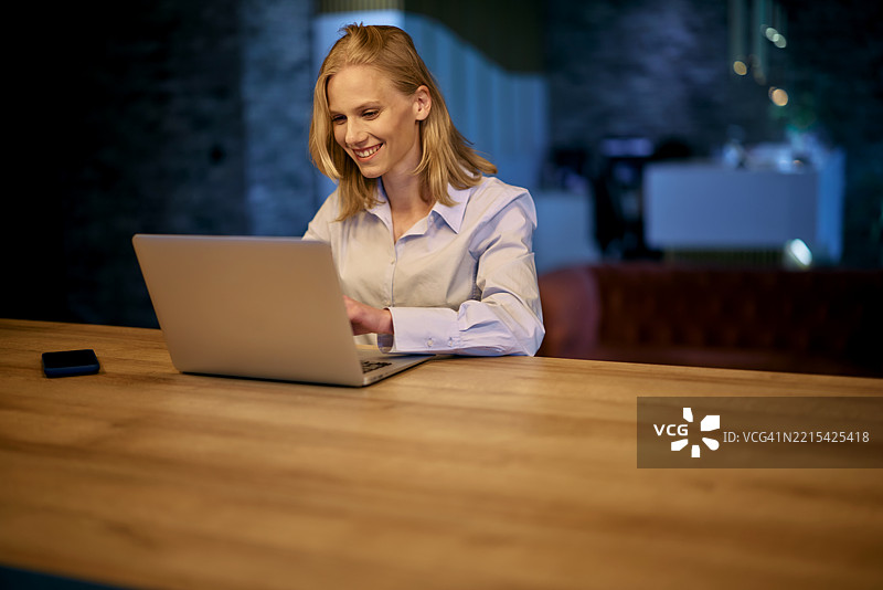 在现代办公室里加班的女商人使用笔记本电脑图片素材