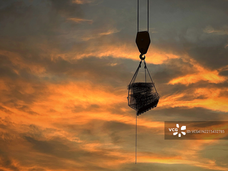 建筑工地上吊起材料的起重机剪影图片素材