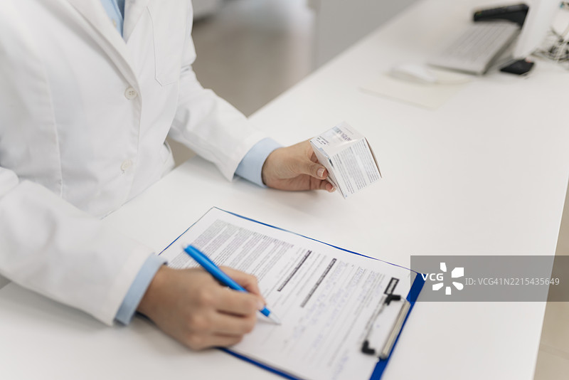 药剂师检查药物信息并填写处方表图片素材