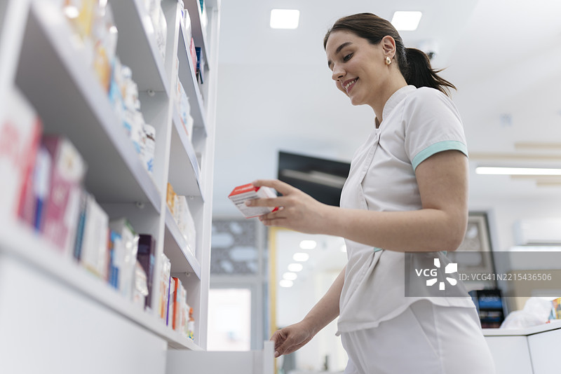 药剂师在药房从货架上取药图片素材