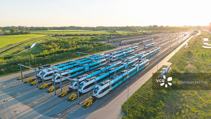 从无人机视角俯瞰蓝色和黄色火车的铁路货场图片素材