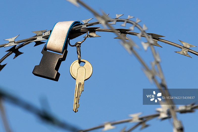 一把钥匙挂在铁丝网上图片素材