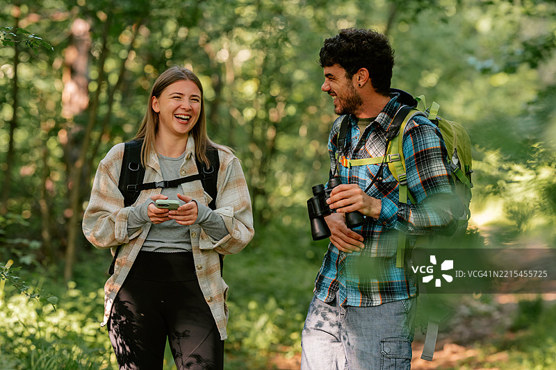 徒步旅行者使用智能手机和望远镜，享受大自然图片素材