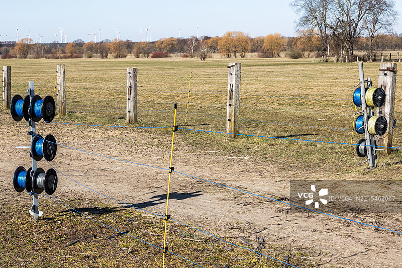 农业田地周围的电围栏电缆卷筒图片素材