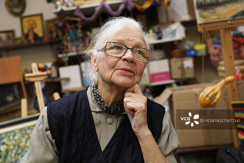 一位80岁以上的老年女性，特写，沉思，身处养老院。她的眼中充满了宁静的悲伤，仿佛承载着岁月流逝和失去时光的沉重。图片素材