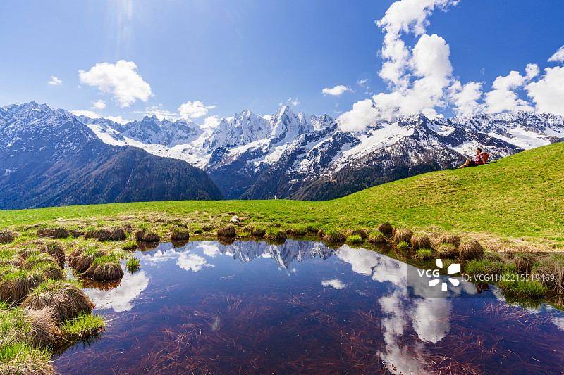 春天的高山草甸上，徒步旅行者正在放松休息图片素材