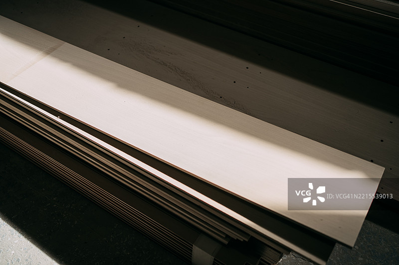 一堆白色木板放在工作室里较暗的木板上图片素材