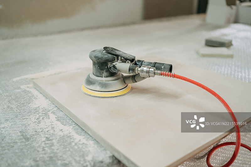 电动砂光机在建筑工地上打磨瓷砖表面图片素材
