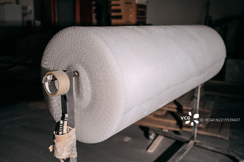 仓库中准备发货的气泡膜卷和包装胶带分配器图片素材