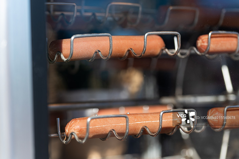 展会食品展示柜内金属滚筒上旋转的热狗图片素材