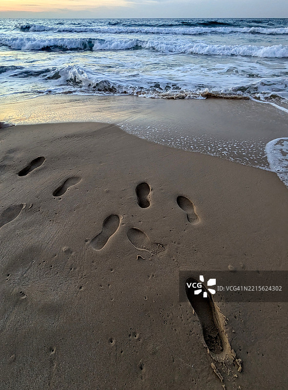 日落时分水边的脚印图片素材