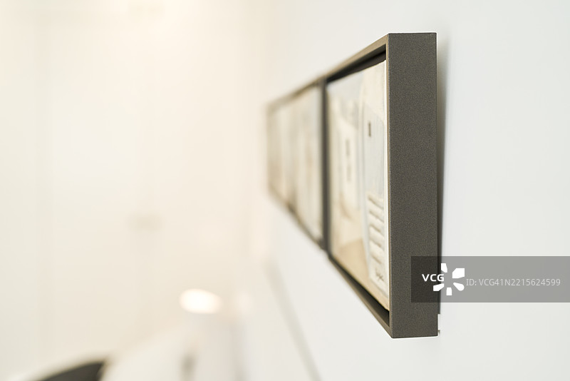 明亮房间内白墙上挂着现代艺术画作图片素材