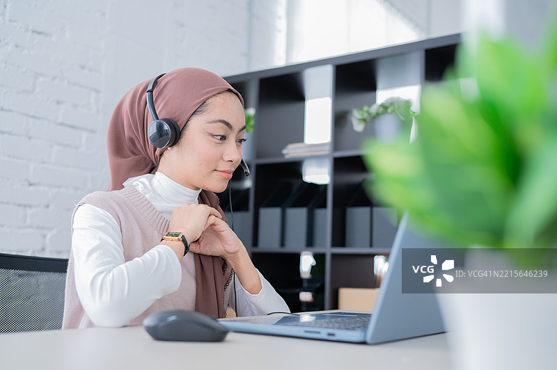 亚洲马来西亚女商人佩戴耳机进行在线视频会议图片素材