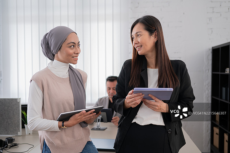 两位亚洲女商人在办公室合作并微笑的照片图片素材