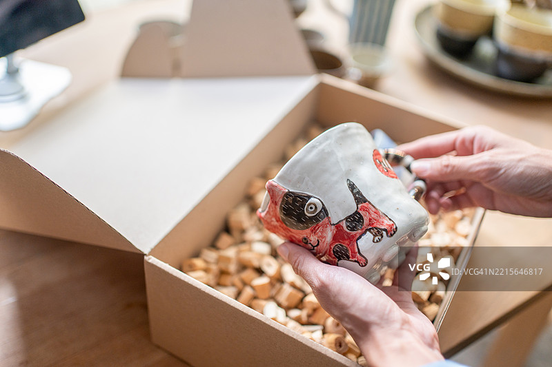 美丽的白人女性穿着休闲服，面带幸福和成功的微笑，在家中打包、销售在线购物产品，进行自己的生意或创业。电子商务概念图片素材