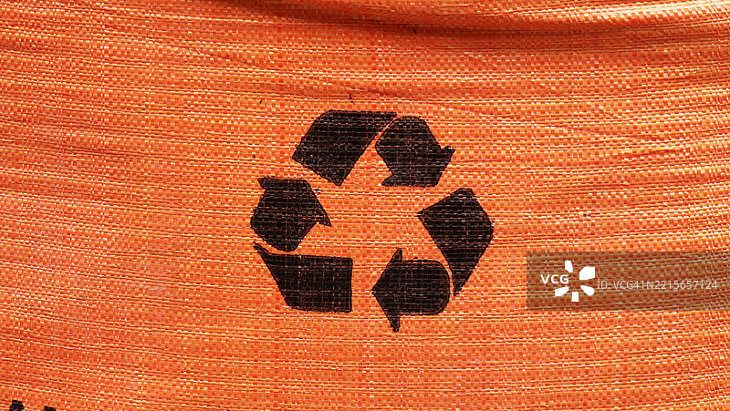 橙色皱纹防水布上的回收标志。阳光。自然色彩。全画幅16x9 巴黎，法国图片素材