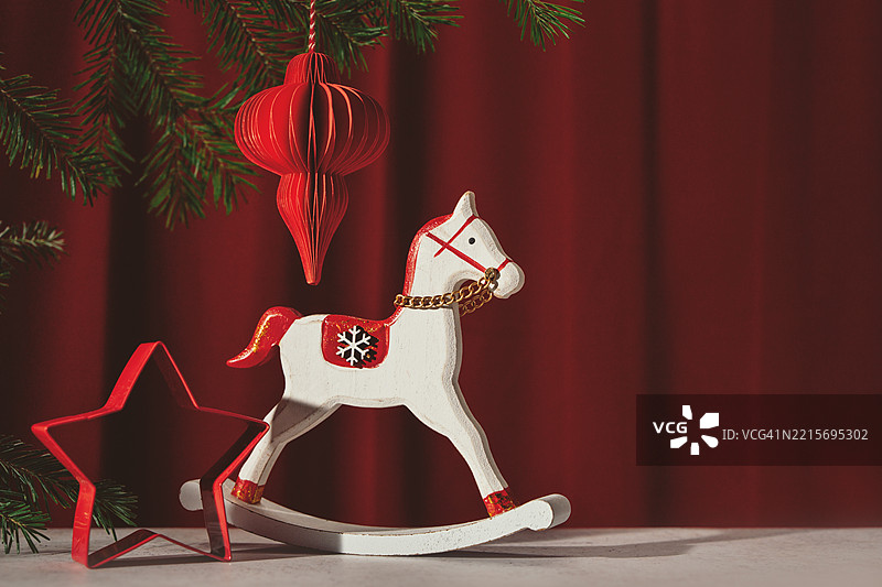 摇马和红色装饰品在圣诞树旁图片素材