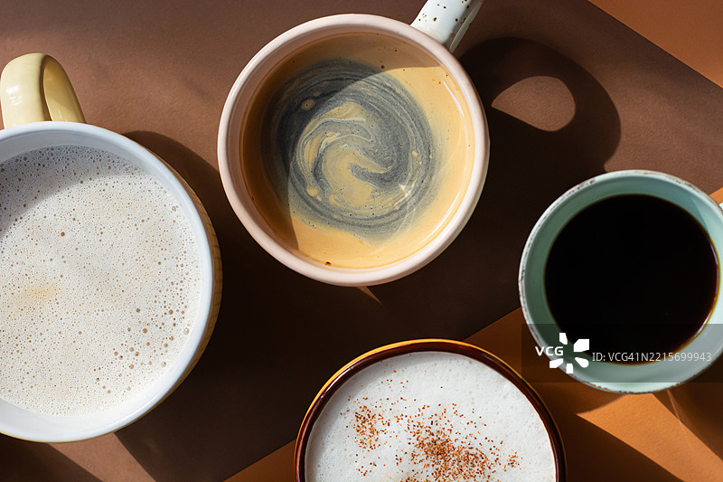 不同呈现方式的早晨咖啡，背景为橙色和陶土色。各种咖啡饮品。图片素材