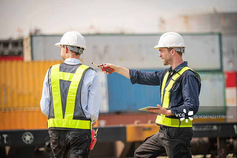工业工程师或工人在运输铁路和集装箱运输中的物流检查是团队合作的物流管理和现代工业。图片素材