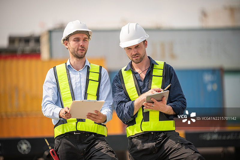 运输铁路和集装箱运输的工业工程师或工人进行物流检查是团队合作的物流管理和现代工业。图片素材