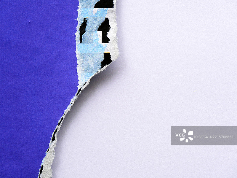 撕裂的蓝色和黑色海报在白色纸张背景上。阴影。阳光。自然色彩。4:3格式。法国巴黎。图片素材