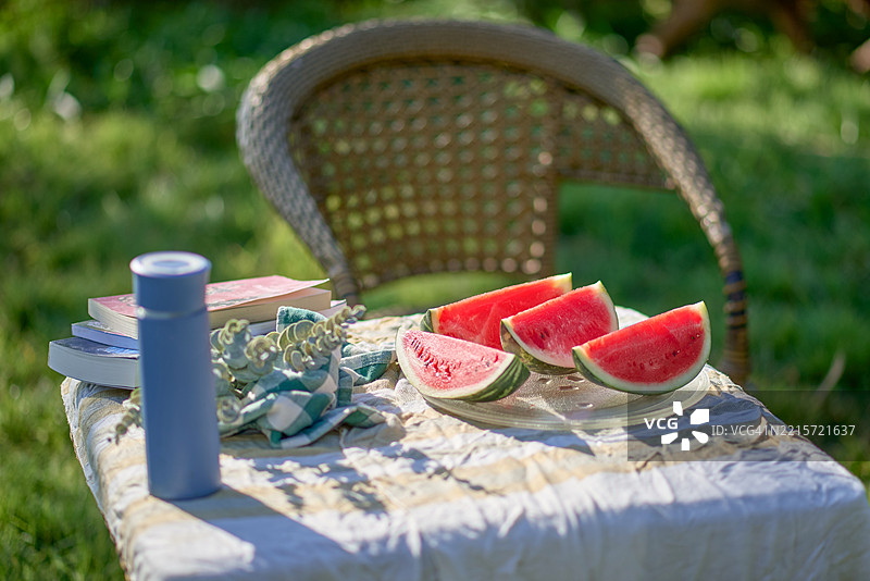 花园中的西瓜与书籍带来的夏日清凉图片素材