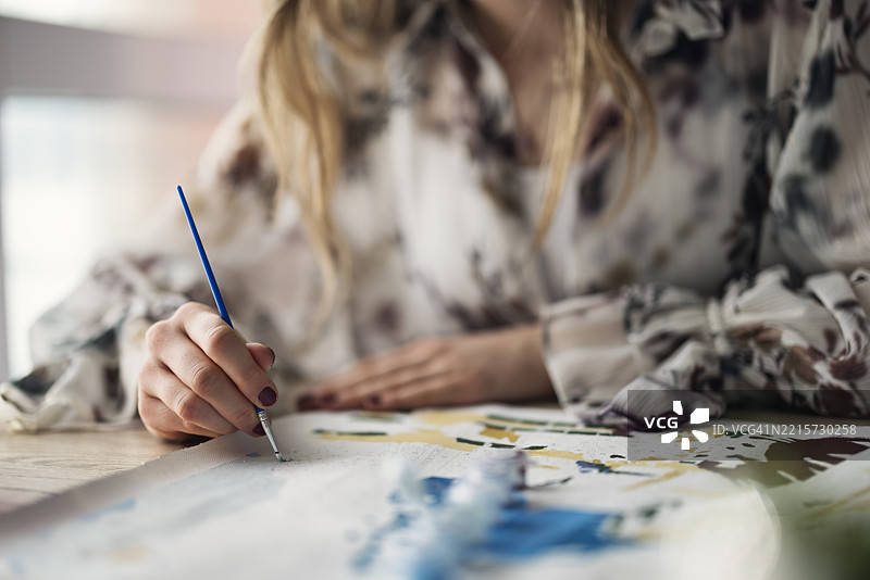 年轻女性在桌子上进行数字画绘画。图片素材