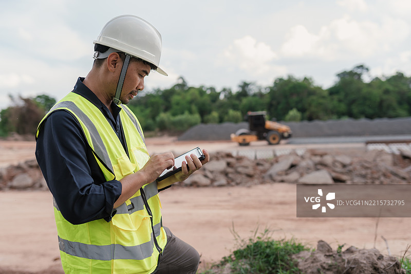 土木工程师在铁路施工现场使用平板电脑，专注于检查和项目管理任务。图片素材