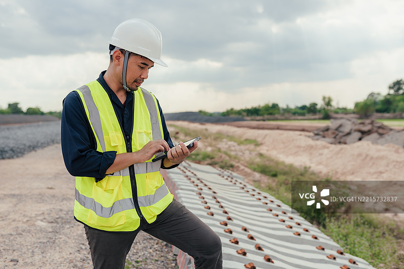工程师在现场检查混凝土铁路枕木，并使用平板电脑更新施工数据。图片素材