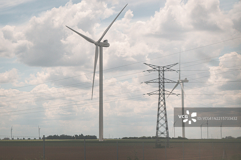 风力发电机与电力线共存图片素材